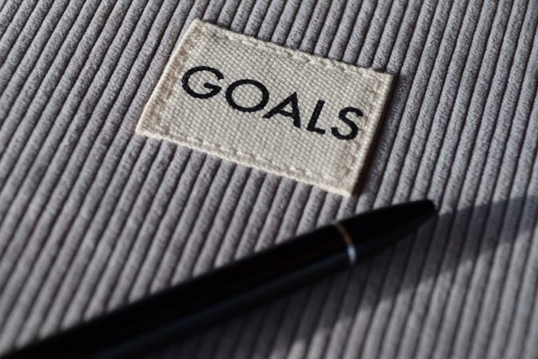 black pen on grey textile with a tag that says "GOALS"