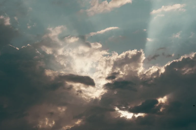 Sunbeams breaking through dramatic clouds at daybreak